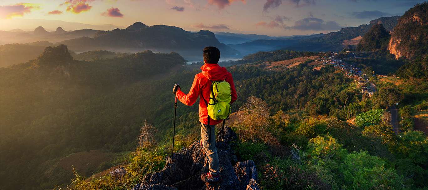Traveller overlooking a mountain valley at sunrise